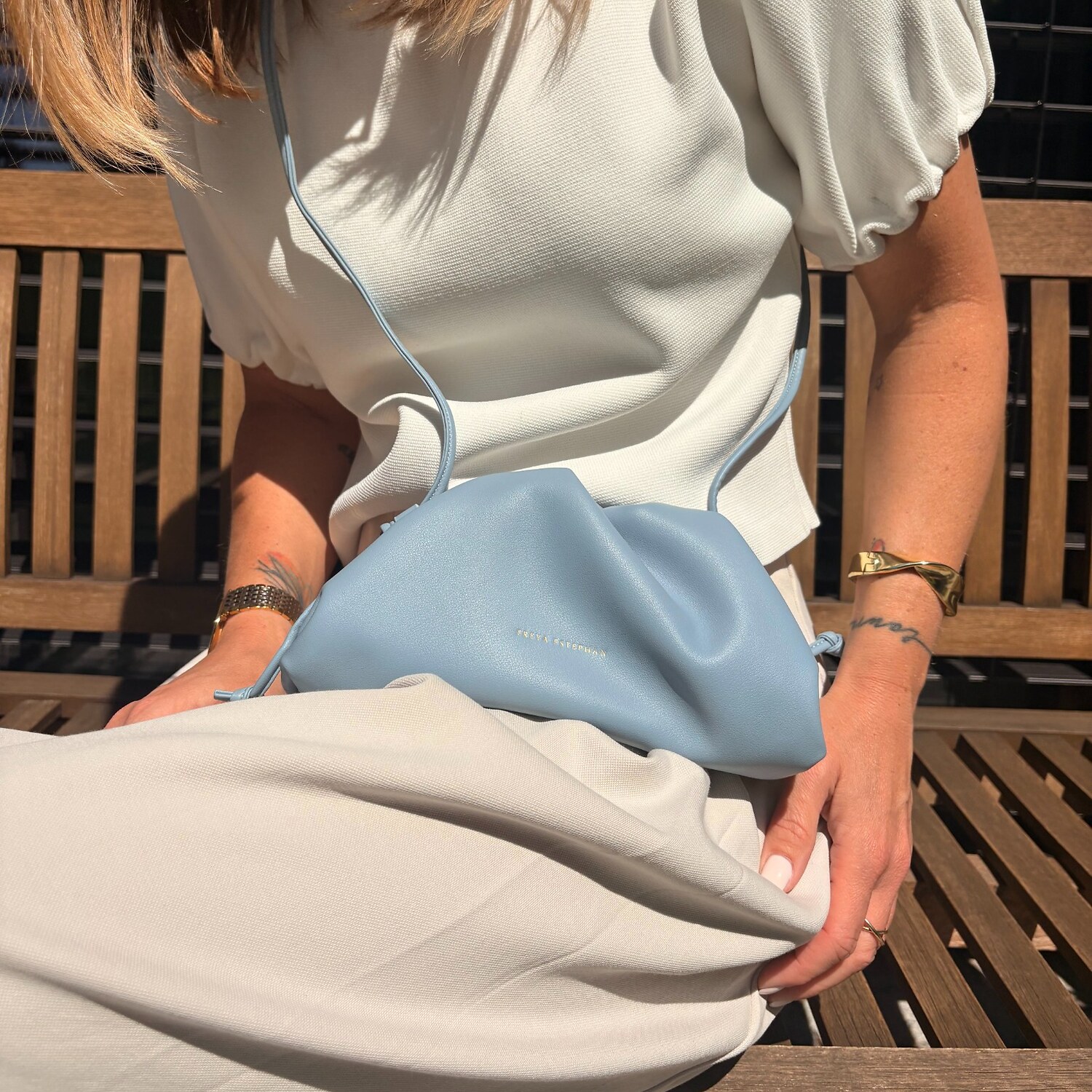 Ledově modrá malá kožená kabelka Freya Estephan se světlým outfitem